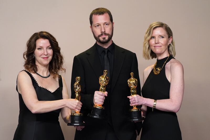 Raney Aronson-Rath, Mstyslav Chernov, and Michelle Mizner after they won the award for best documentary feature film for 20 Days In Mariupol. (Jordan Strauss/Invision/AP)