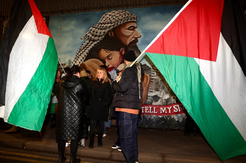 People gather at the Palestine Murals on the Falls Road following the announcement of a ceasefire in Gaza. PICTURE: MAL MCCANN