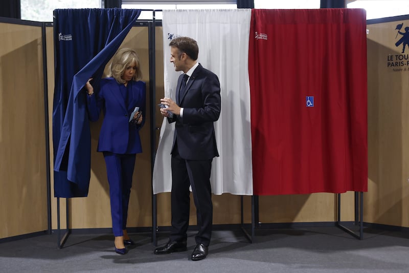 French President Emmanuel Macron and his wife Brigitte Macron leave the voting booth before voting for the second round of the legislative elections in Le Touquet-Paris-Plage, northern France (Mohammed Badra, Pool via AP)