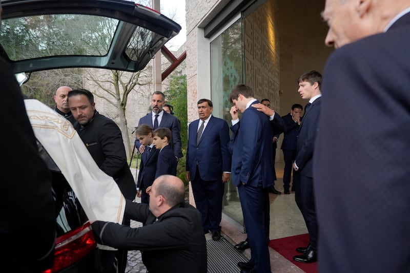 Prince Rahim Al-Hussaini watches with his children as the coffin is placed in a hearse (Ana Brigida/AP)