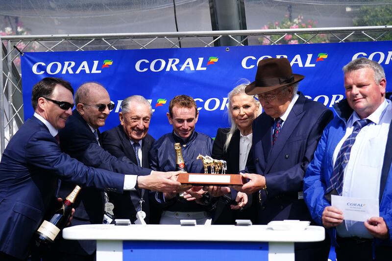 Jockey Ryan Moore (centre) and trainer Aidan O'Brien (left) celebrate with the trophy after winning the Coral Eclipse aboard City Of Troy on day two of the Coral Summer Festival at Sandown Park Racecourse, Esher. Picture date: Saturday July 6, 2024.