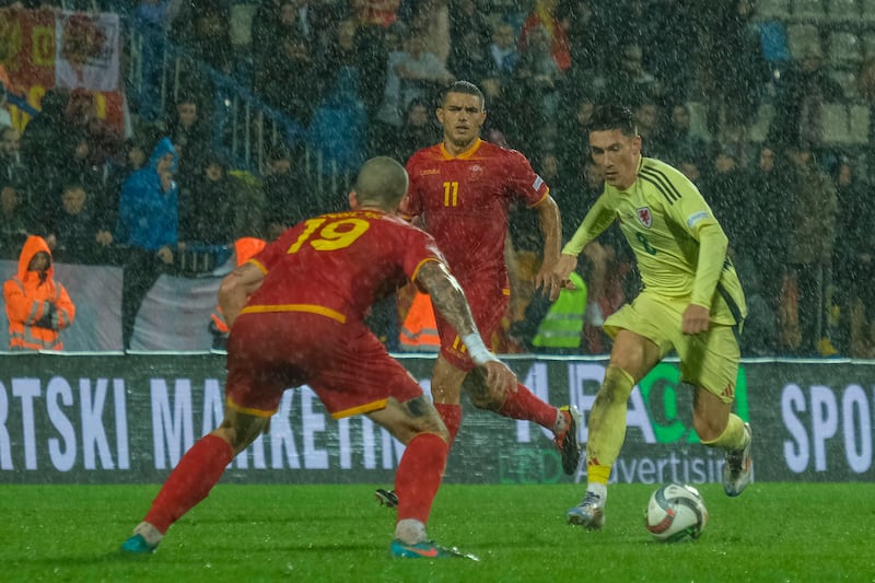 Wales goalscorer Harry Wilson (right) takes on Montenegro’s Slobodan Rubezic (Risto Bozovic/AP)