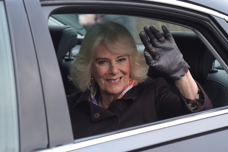 Queen Camilla waves during her visit to the hospice