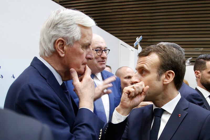 President Emmanuel Macron whispers to then EU chief Brexit negotiator Michel Barnier as he visits the International Agriculture Fair in Paris (Michel Euler/AP)