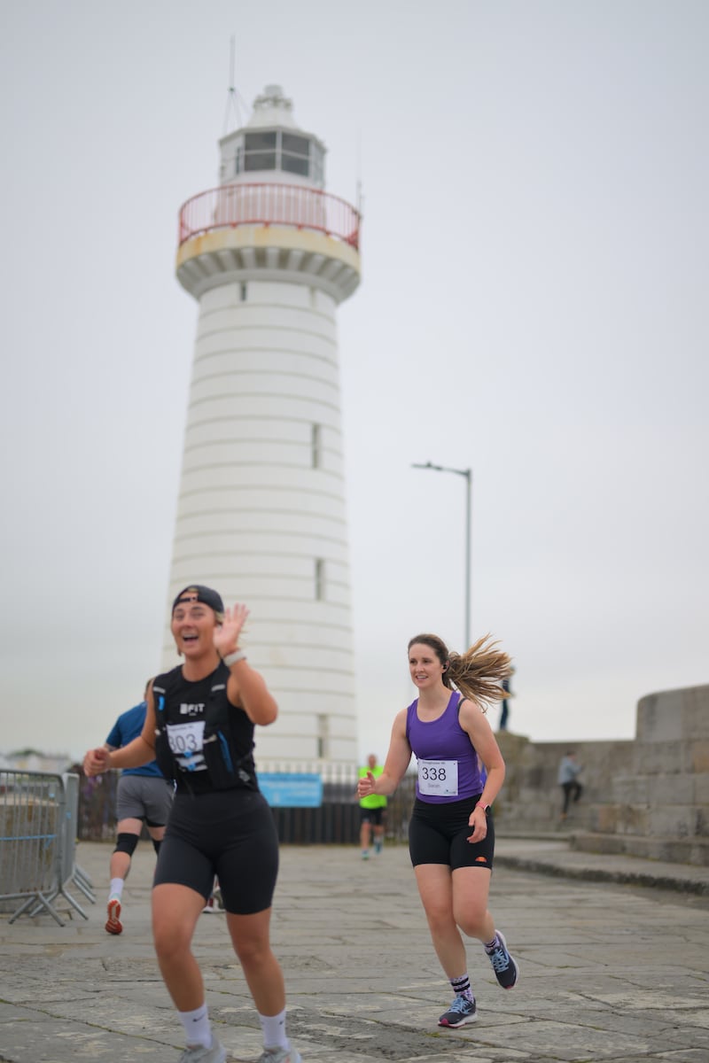 Group of runners in 5k race in front of white lighthouse