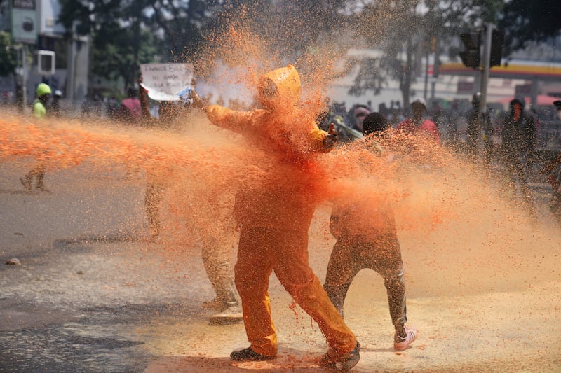 Protesters scatter as police spray a water cannon at them in Kenya during a protest earlier this week (Brian Inganga/AP)
