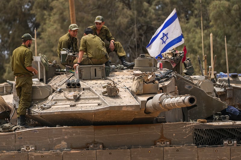 Israeli soldiers work on a tank near the Israeli-Gaza border (Tsafrir Abayov/AP)