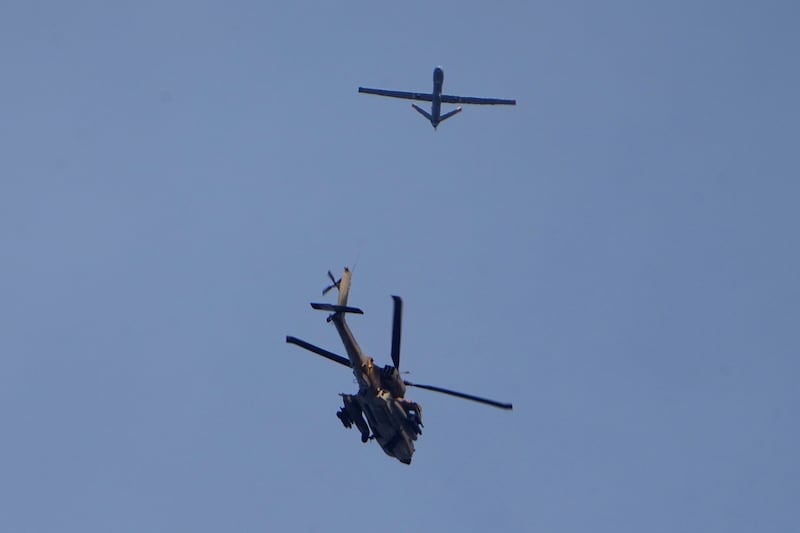 An Israeli military Apache helicopter and a drone fly close to the Gaza strip (AP Photo/Ariel Schalit)