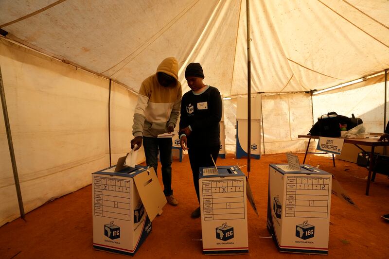 A man assisted by an electoral worker casts his ballot at a polling station in Alexandra, near Johannesburg, South Africa (Themba Hadebe/AP)