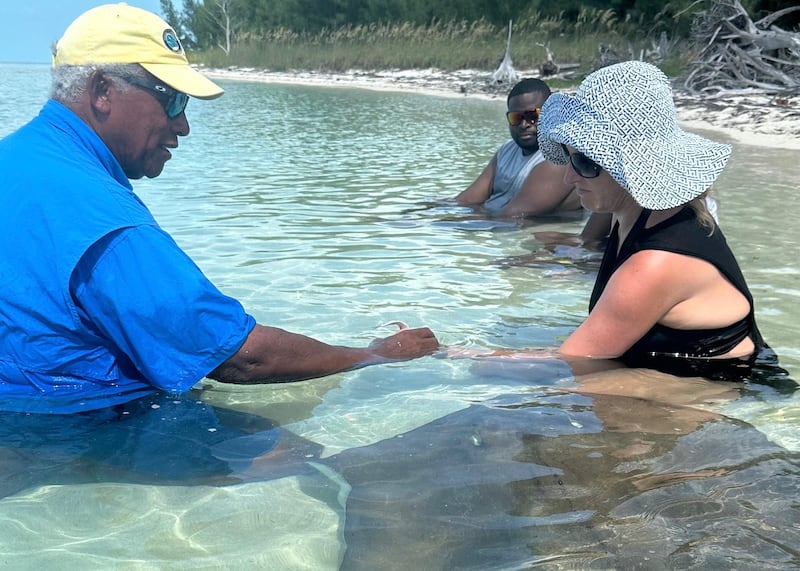 Keith demonstrates how to feed stingrays safely (Bahamas Tourist Board)