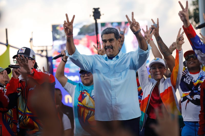 Venezuelan President Nicolas Maduro flashes victory hand signs at supporters during a pro-government rally in Caracas, Venezuela (Cristian Hernandez/AP)