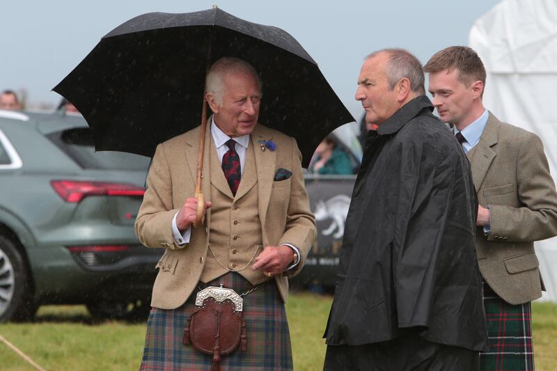 Attendees, including the King, were forced to shelter from the rainy weather