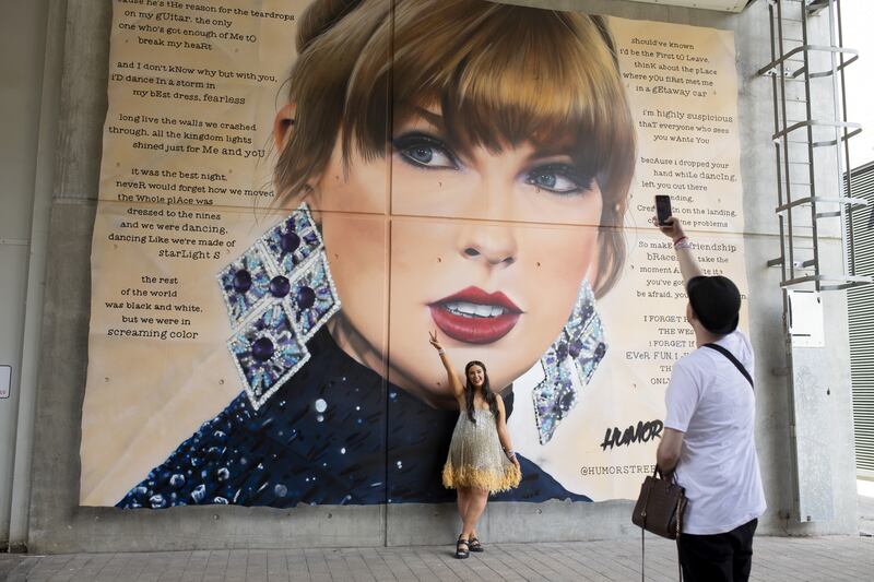 A fan poses in June in front of a mural of Taylor Swift at Wembley Stadium in London