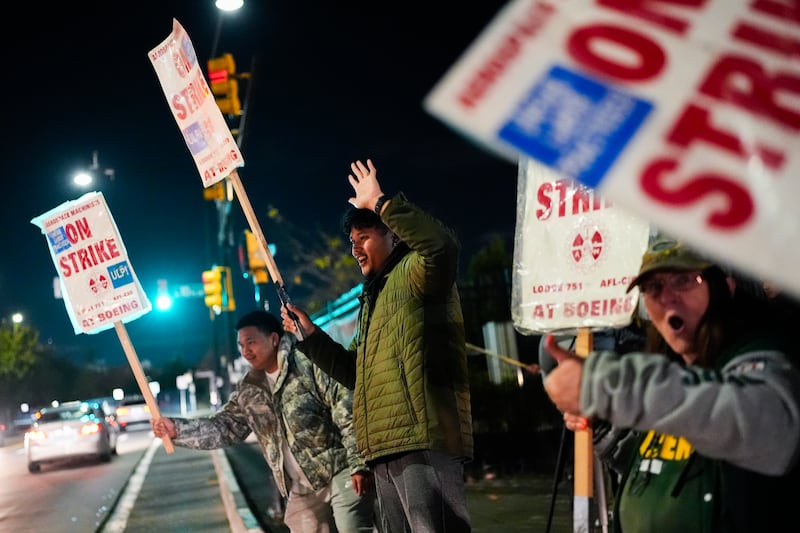 Boeing employees, including assembler Tyrone Hipolito, centre, work the picket line (Lindsey Wasson/AP)