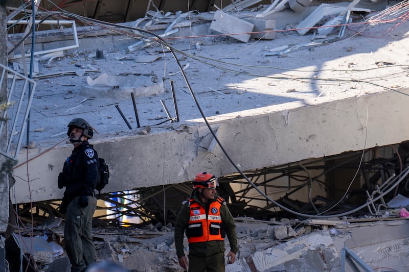 People examine the damage caused by a Houthi missile (Ariel Schalit/AP)