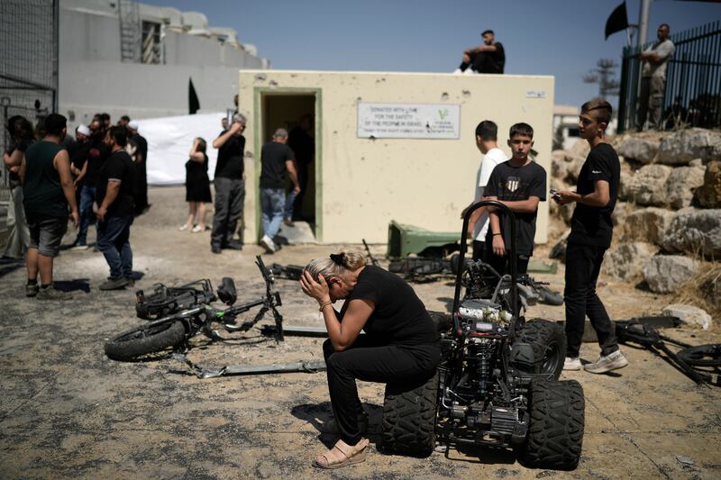 A woman from the Druze minority weeps near the site where 12 children and teens were killed in a rocket strike (Leo Correa/AP)