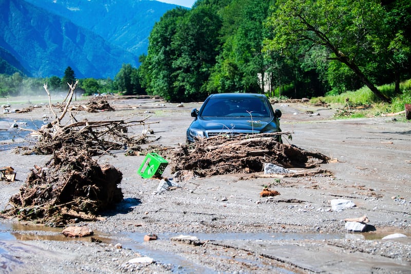 A car stuck in the mud at Sorte village after a landslide caused by the bad weather and heavy rain in the Misox valley, in Lostallo, southern Switzerland (Samuel Golay/Keystone via AP)