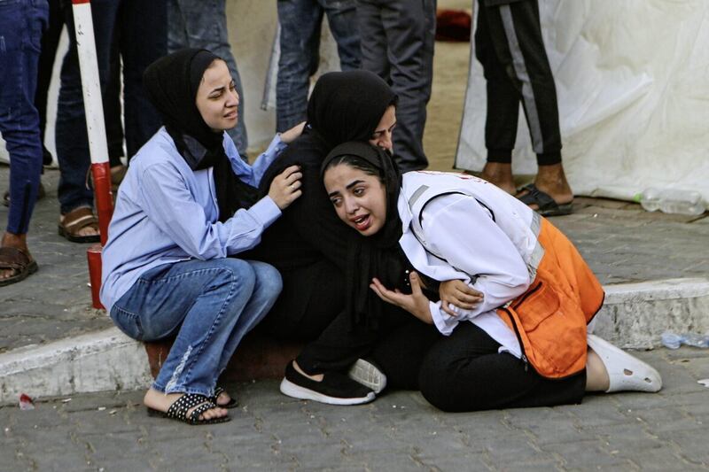               A Palestinian medic, right, cries after learning about the death of a relative at the al-Shifa hospital, following Israeli airstrikes on Gaza City