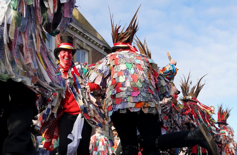 Morris dancers perform in the streets of Whittlesea, Cambridgeshire while wearing colourful attire