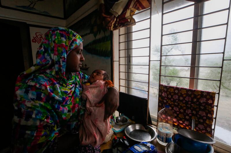 An evacuated woman and infant sit inside a shelter after Remal lashed Bangladesh’s southern coast (AP Photo/Abdul Goni)