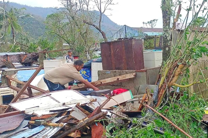 A resident recovers belongings from their damaged home caused by Typhoon Man-yi (MDRRMO Viga Catanduanes via AP)