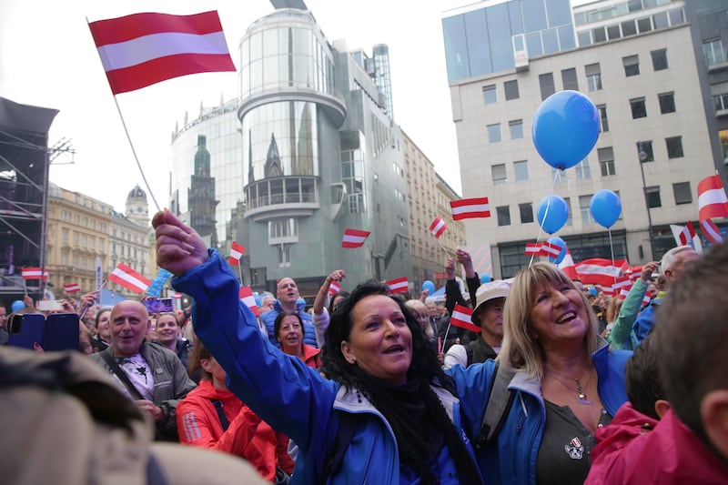 Supporters wave Austrian flags during the final election campaign event of the Freedom Party (Heinz-Peter Bader/AP)