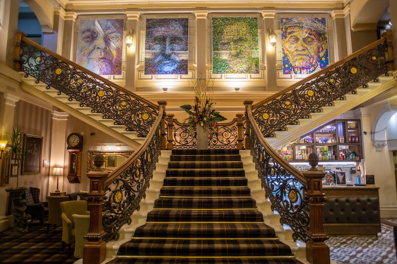 Pointillism paintings hang at top of staircase in Inverness Art Museum and Gallery in Scotland