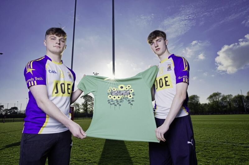 Rory Moore and Oisin McDonnell, members of St Brigid's GAC and Queen's University GAA, with the Team Fionnt&aacute;n jersey, who will be taking part in Sunday's Belfast City Marathon in memory of Fionnt&aacute;n McGarvey (18) from Belfast, who died suddenly in January after an incident outside a bar in the south of the city the month before