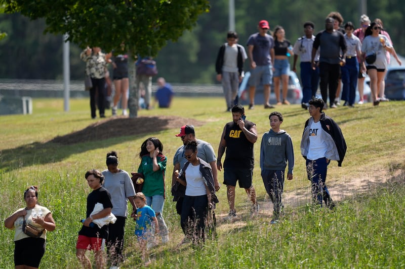 Students and parents walk off campus at Apalachee High School (Mike Stewart/AP)