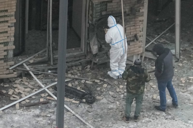 Investigators work near a scooter at the site where Lieutenant General Igor Kirillov was killed by an explosive device planted close to an apartment block in Moscow (AP)