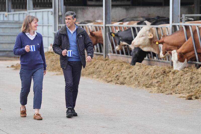 Prime Minister Rishi Sunak walks with farm owner Rachel Rowlinson