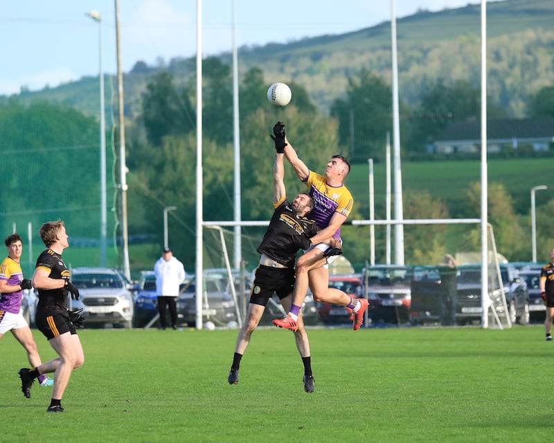 Derrygonnelly's Stephen McGullion punches the high ball away from Brian Mullin of Erne Gaels.