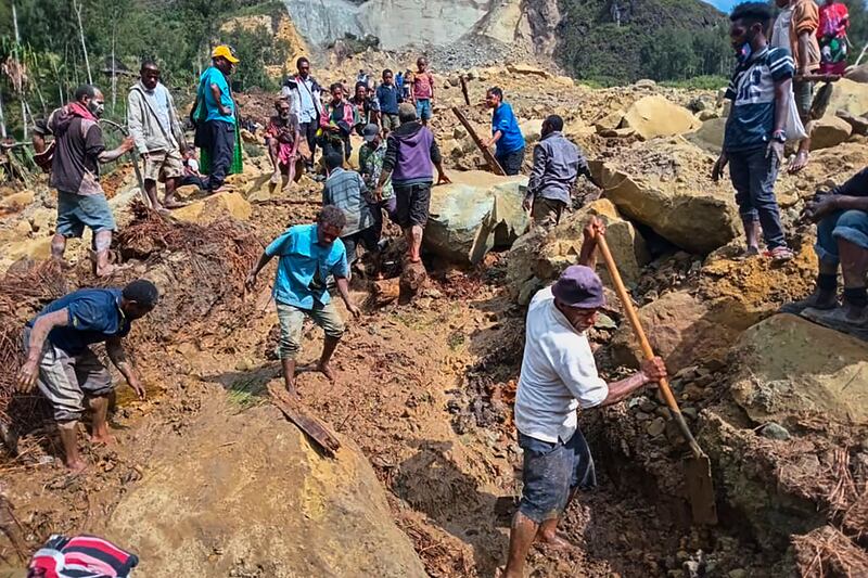 Villagers search through the debris following a landslide in Yambali, in the Highlands of Papua New Guinea (Mohamud Omer/International Organisation for Migration/AP)