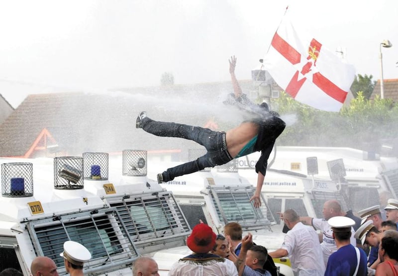 PACEMAKER BELFAST  12.07.13. PICTURE BY DAVID FITZGERALD.Riots kick off at Woodvale as the parades are not allowed to pass Ardoyne. A man on top of a police landrover gets blown off by the water cannon.Please Byline DAVID FITZGERALD/PACEMAKER PRESS. 