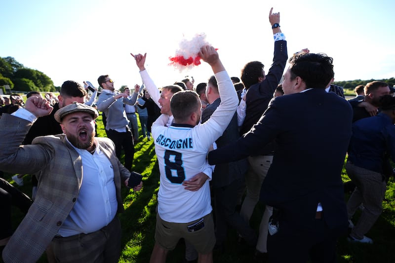 England fans celebrate on the race track at Sandown Park