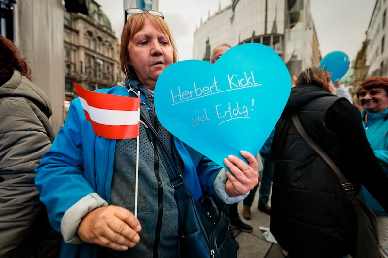 Astrid holds a heart shaped balloon with a good luck wish for Herbert Kickl, leader of the Freedom Party of Austria, during his final electoral campaign rally, held outside the St Stephen Cathedral, in Vienna (Andreea Alexandru/AP)