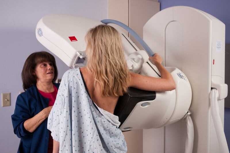 A nurse helping a female patient during a digital mammogram