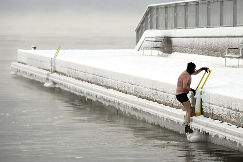 A man braves the icy sea in southern Helsinki, Finland (Vesa Moilanen/Lehtikuva via AP)