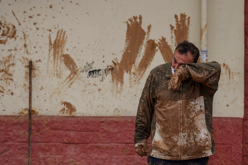 A man wipes mud off his face in an area affected by floods in Catarroja, Spain (Manu Fernandez/AP)