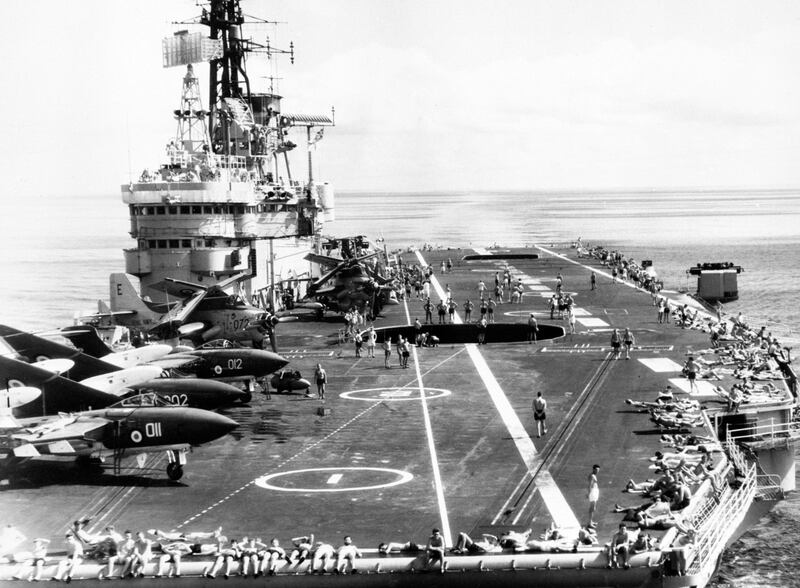 Sailors bask in the sun on board the aircraft carrier HMS Ark Royal in the Mozambique Channel. Aircraft are on board