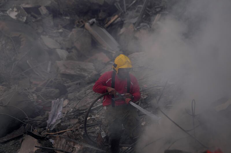 A firefighter extinguishes a fire at the site of an Israeli air strike that hit central Beirut on Saturday (Hussein Malla/AP)