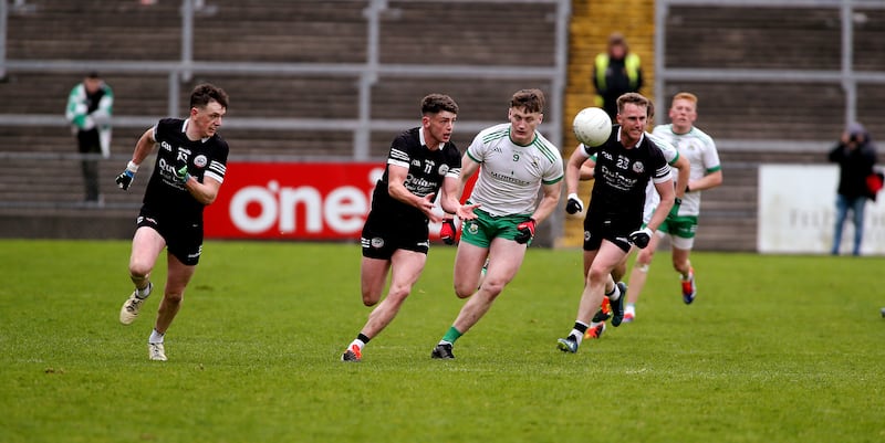 Kilcoo's Anthony Morgan, Christopher Rooney and Paul Devlin chase Burren's   Odhran Murdock