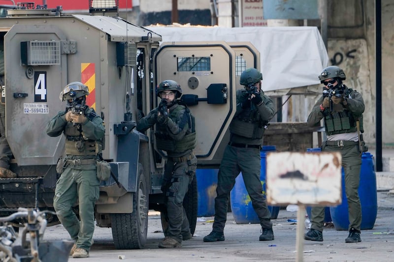 Israeli security forces take up positions during a military raid in the Askar refugee camp near the West Bank city of Nablus (Majdi Mohammed/AP)