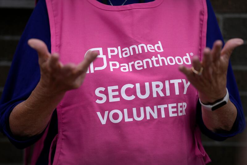 A Planned Parenthood clinic patient escort stands outside the building in Iowa (Charlie Neibergall/AP)