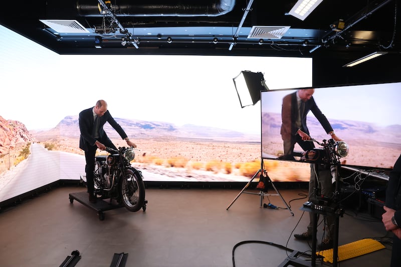 The Prince of Wales tries out a motorbike in the state-of-the-art virtual production studio at Ulster University in Belfast