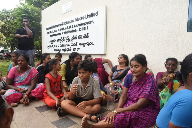 Relatives of the victims killed in the fire sitting outside the factory (AP Photo)