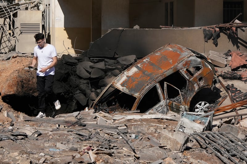 A man walks on rubble at the site of an Israeli airstrike in Beirut’s southern suburbs (AP Photo/Hassan Ammar)