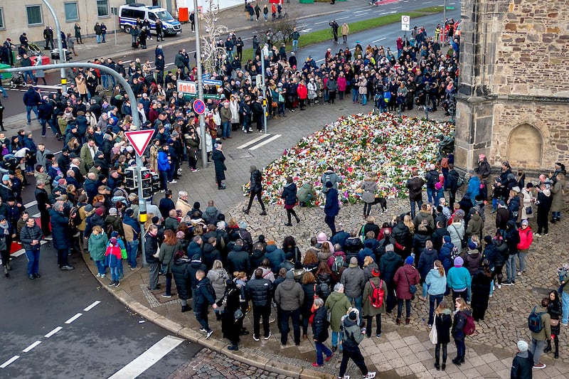 People have gathered to lay flowers and light candles at the entrance of the Johannis church near the scene of the deadly attack (Michael Probst/AP)