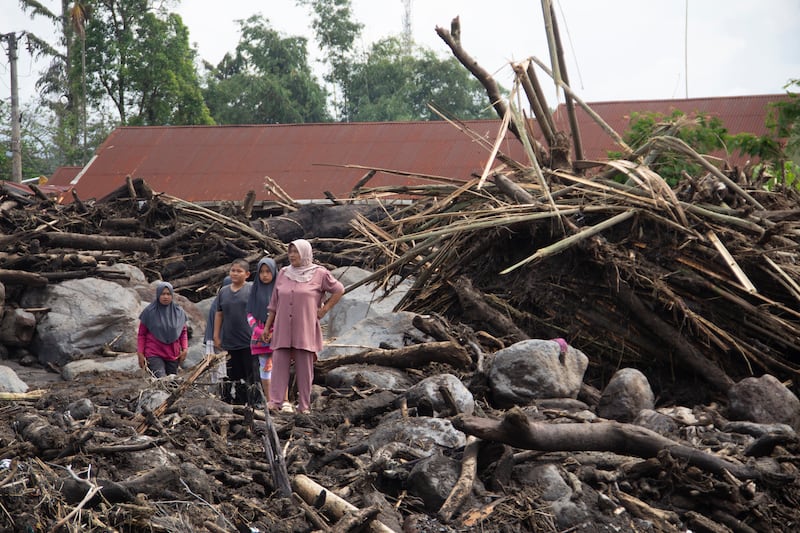 People inspect the damage by a flash flood in Agam, West Sumatra, Indonesia (Sutan Malik Kayo/AP)
