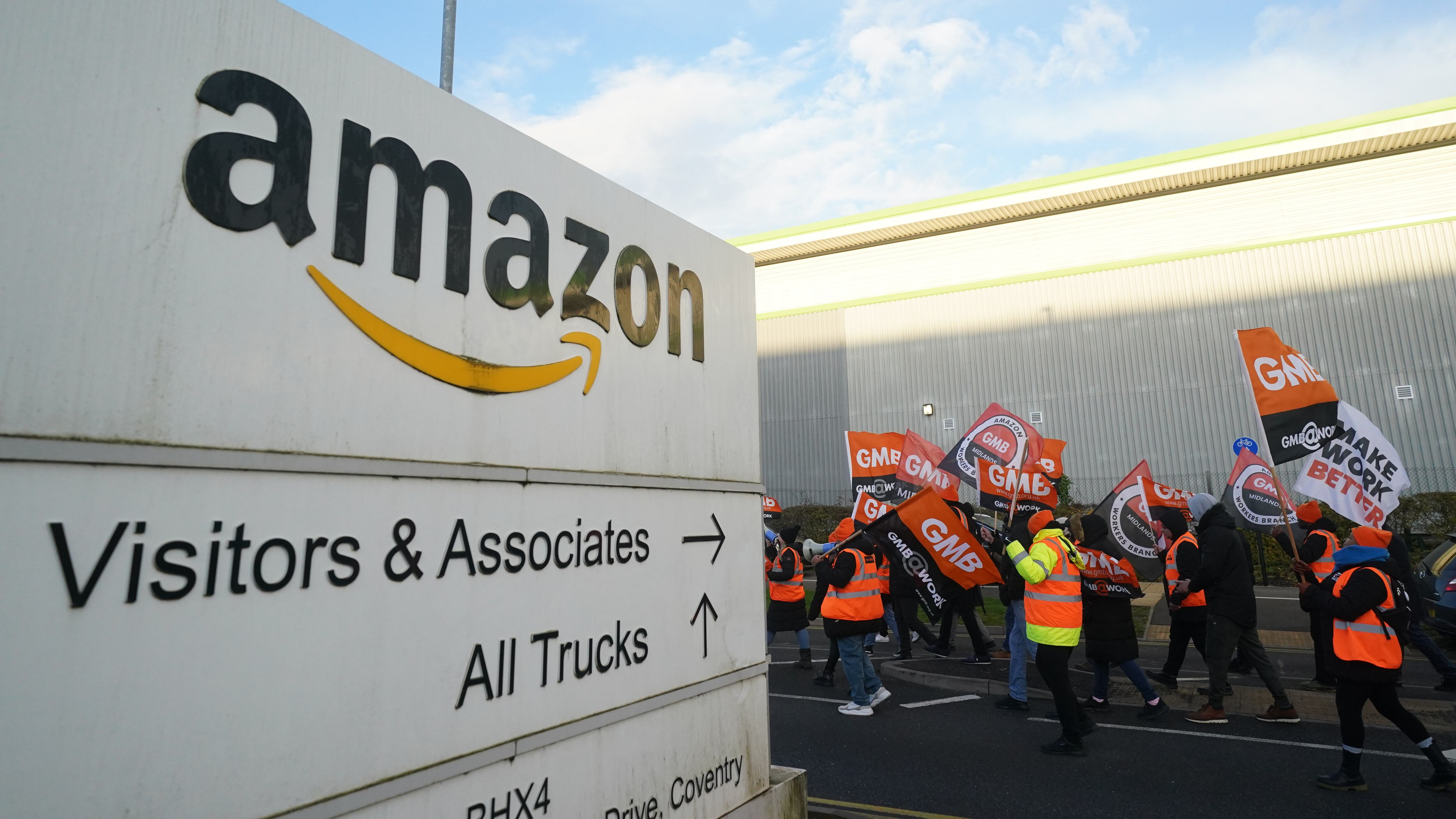 Members of the GMB union on the picket line stand in front of a freight lorry outside the Amazon fulfilment centre in Coventry